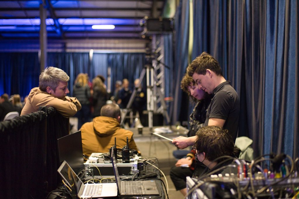 Event production team operating audiovisual equipment